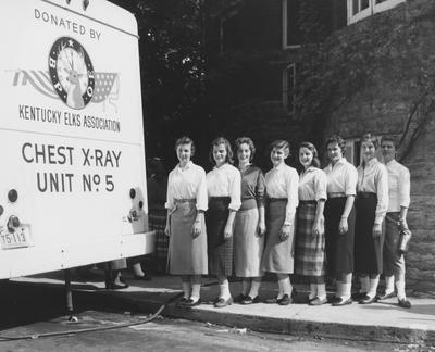 Registration--Group of female students beside an X-ray unit. From left to right: unidentified, Elaine Long, unidentified, Peggy Rollins, Joan Weggins, and Judy Semmons. Received September of 1957 from Public Relations