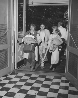 Students moving in; a man and two women. Received December 11, 1961 from Public Relations