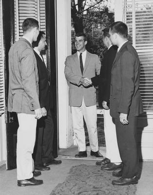 Steve Clark (center) is shaking an unidentified man's hand and is standing with three other unidentified men during Rush. This photo is on page 18 in K-Book