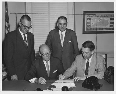 Phi Kappa Tau members; two unidentified men signing a paper. Received August 27, 1963 from Public Relations