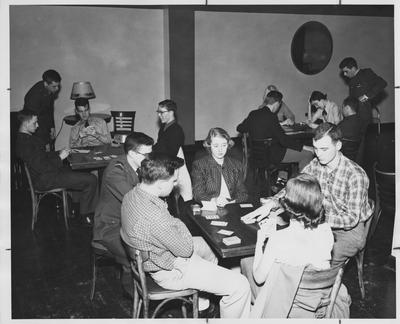 Students playing a Bridge game in the Student Union Building. Sitting at the back left table, on the far left, is John Wesley Faulkner