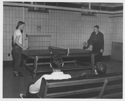 Men playing ping pong  in boy's dorm