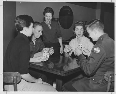 Four people playing a card game; second from right is Dale Primrose. Received August 7, 1957 from Public Relations. This image appears third on page 58 in the 1957-58 K-Book