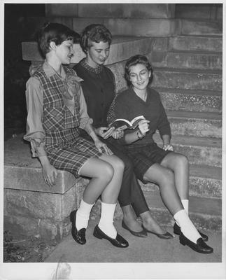 Three women reading a book. Herald-Leader photo. Received October 20, 1959 from Public Relations. Woman in the center is Myra Tobin