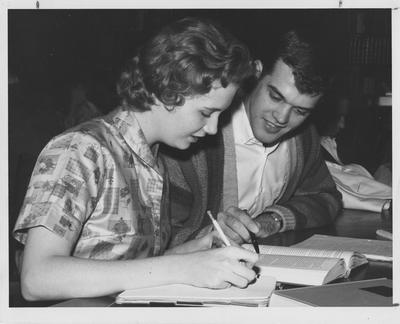 Barbara Zweifel (seated, left), member of Delta Zeta, and Steve Clark (seated, right), member of Sigma Alpha Epsilon, are studying together. This photo appears on page 20 in the 1960 K-Book