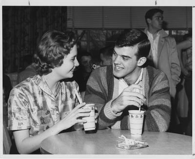 Barbara Zweifel (left) is seated next to and conversing with Steve Clark (right) at the K-Lair. This photo appears on page 14 in the 1960 K-Book