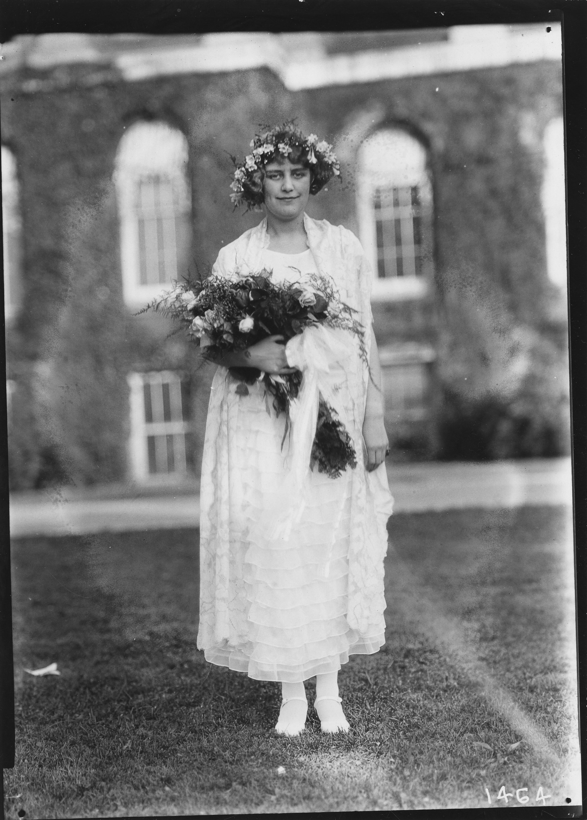 A young woman in a white dress, holding a bouquet of roses, wearing a ...