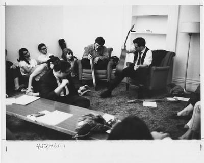 Robert (Bob) Ladner (seated, right) is playing different instruments and lead a Free University session in ethnomusicology. The Free University was founded by Meg Tassie in 1968 and led by Robert Ladner, Jeff DeLuca, and Dr. David Denton. This photo appears first on page 161 in the 1969 Kentuckian
