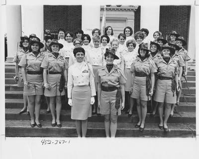 Kentucky Babes: thirty one women standing in uniforms on steps, some with sabers and one with a flag. This image appears first on page 367 in the 1969 Kentuckian