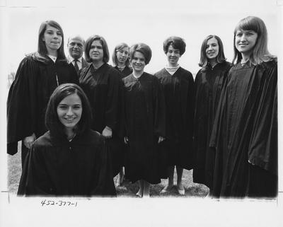 Eight women in graduation gowns standing or sitting and one man standing. This image appears first on page 377 in the 1969 Kentuckian