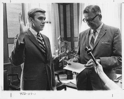 President Albert Kirwan (right) is swearing Tim Futrell into an office of the Student Government; This photo is in the 1969 Kentuckian on page 117, image number 1