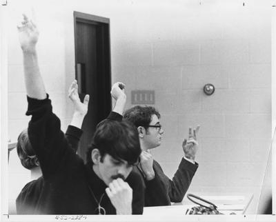 Four unidentified members of Students for Action and Responsibility at a meeting in a classroom; This photo is in the 1969 Kentuckian on page 238, image number 1