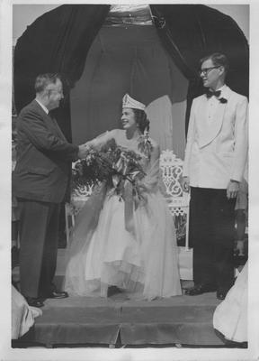 A queen with unidentified man shaking hands with Dr. Donovan