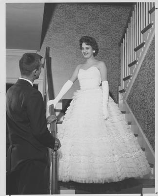 Barbara Zweifel stands on a staircase looking down at Steve Clark; This photo is in the 1960 K - Book (student handbook) on page 37