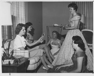 Barbara Zweifel (seated left on couch) at a sorority Rush party; This photo is in the 1960 K - Book (student handbook) on page 17