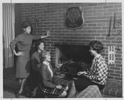 Kappa Delta Sorority sisters popping popcorn by the fireplace; From left to right: Diane Schorr, Kennie Bowling, Brenda Marquis, Brenda Booke; This image is in the 1963 Kentuckian on page 100, image 1