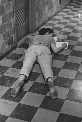 Doing homework lying on the floor of an unidentified sorority house