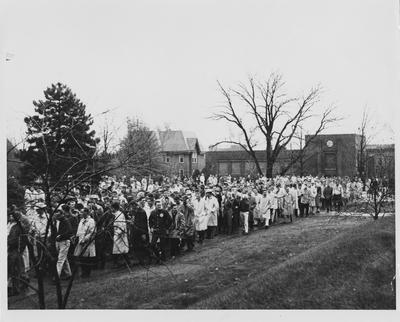 Students march in protest against faculty ruling on holiday march to McVey Hall after circling Faculty Club; Buildings in background are Faculty Club (Patterson House) and Law School; Picture appeared in 1959, November 25 Kentucky Kernel
