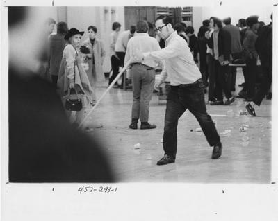 Man cleans up after protesters; This image is in the 1969 Kentuckian on page 293, image 1