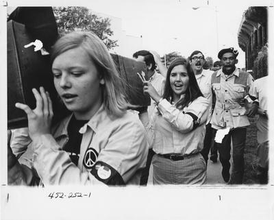 On the day that Eugene McCarthy’s bid for the 1968 Democratic presidential nomination at the convention was unsuccessful, students march from the McCarthy campaign headquarters on Woodland Avenue to Euclid Avenue to the University of Kentucky Student Center in a “funeral” procession to mourn the passing of democracy and the Democratic party.  Marchers carry a coffin and wear black arm bands and upside-down McCarthy buttons.  Photo is in the 1969 Kentuckian on page 252. See the Kentucky Kernel article from 1968 August 30
