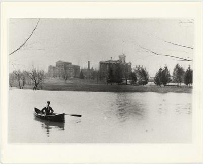 Student canoes on a pond on the site of the present student center; Behind left to right are: Whitehall, Administration, and Gillis buildings
