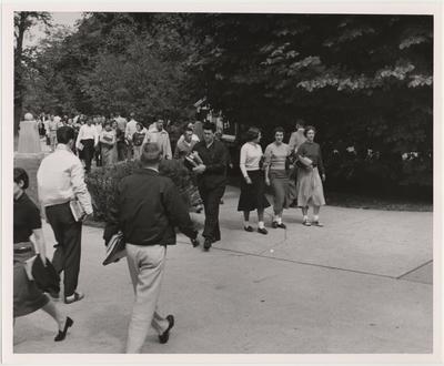 Students walking to class; Tub Ternell (wearing white jacket) faces camera