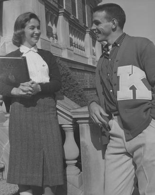 Pat Nallinger, Alpha Gamma Delta sorority member and UK cheerleader talks to an unidentified male student who is a letterman on the steps of the Margaret I. King Library