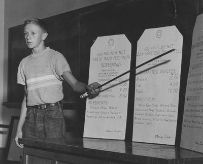 Young boy describing his entry for the Tag on the Bag Contest; Image used at the 1951 State Fair