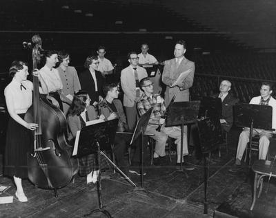 Members of an ensemble are preparing for the 1954 - 55 Music Festival