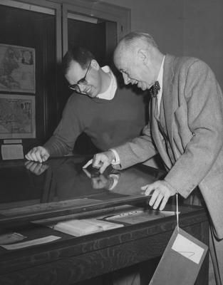 William Randal Duppes (left), a University of Kentucky senior from Louisville, sees a collection of maps and curios shown by the owner, Dwight Tenney