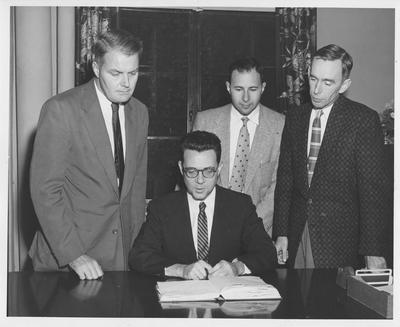 Discussing a clinical psychology internship are Dr. Frank M. Gaines (seated), commissioner in the Department of Health, and standing from the left, Dr. James S. Calvin, head of the University of Kentucky Department of Psychology; Dr. Kenneth Purcell, director of the clinical psychological training program in Kentucky; and Dr. Logan Gragg, superintendent at Eastern State Hospital, Lexington