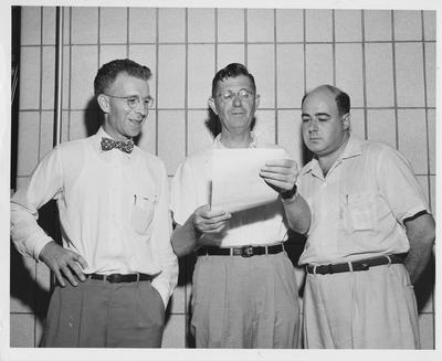 Economics Education Workshop; Reviewing an evaluation report just published are (from left): Dr. H. W. Hargreaves, University of Kentucky; Dr. W. J. Moore, Eastern Kentucky State College; and Dr. Carl E. Abner, University of Louisville; Photographer: Boyd Keenan