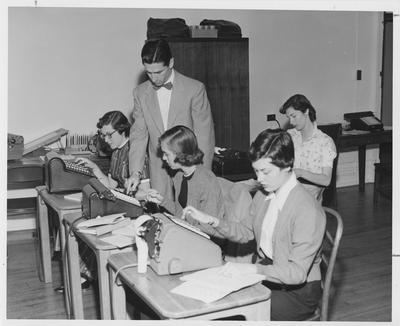 A class of women learning to use adding machines; Helen Shuck, Kathy Stafford, unidentified, and Ann Shirley (back)