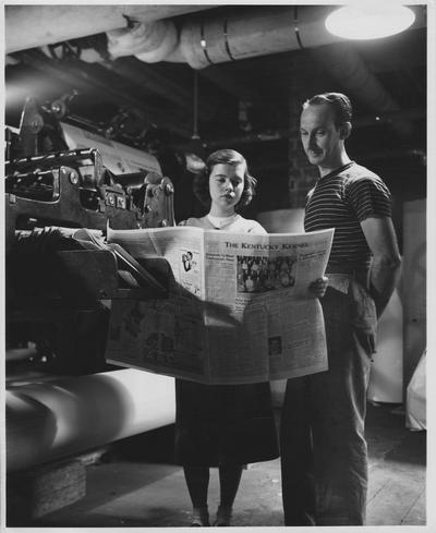 Helen Deiso, editor, checks the Kentucky Kernel with the head pressman, Karl Davis, in the old printing plant