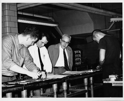 Warren Wheat (second from left) and Professor Niel Plummer (second from right) with others in the Printing room of the Journalism Building