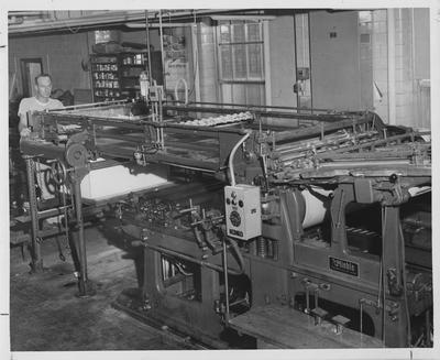 Man stands near the press machine in the Kernel print shop