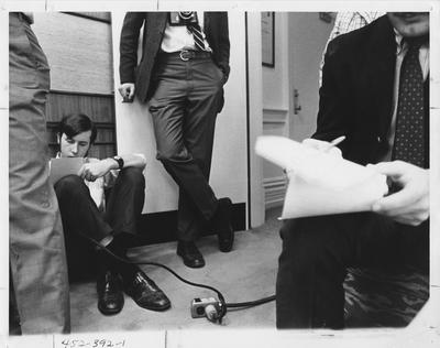 Guy Medes (seated on the floor, left), Managing Editor of the Kentucky Kernel, is at a press conference in the President's office; This image is in the 1969 Kentuckian on page 391, image 1