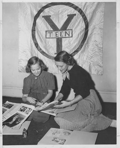 A young woman and a girl cut pictures out of magazines at Y - Teen Club