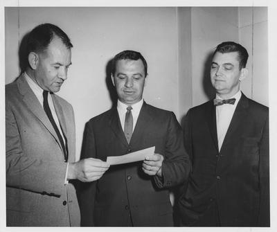 Faculty members of the College of Education looking at a donor's check, including Jess Gardner (left) and James Moore (right)