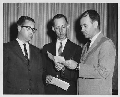 Faculty members of the College of Education looking at a donor's check; From left to right: L. G. McIntyre, Charles Bowman, and Jess Gardner