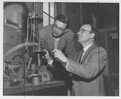 Examining equipment for a research contract awarded the University of Kentucky are Dr. Joseph P. Hammond (right), professor of metallurgical engineering at the University of Kentucky, and James Burka, a graduate student