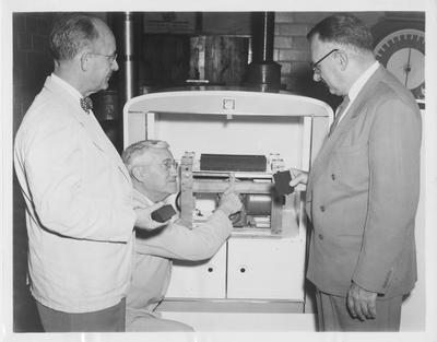 From left to right: Leo M. Chamberlain, vice - president of the University of Kentucky College of Engineering, and Carl R. Shaffer, president of the Xylos Rubber Company, subsidiary of the Firestone Tire & Rubber Company, look over a 