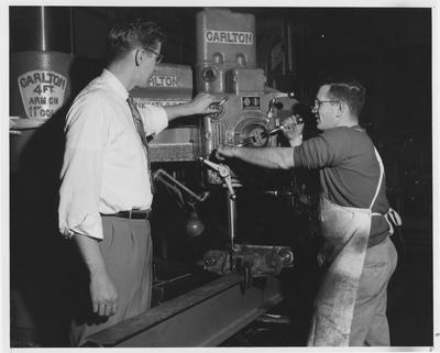 Men using a metal drill press