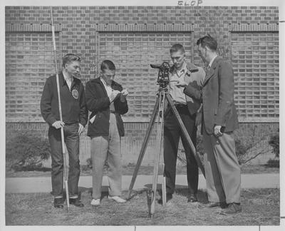 Men teaches younger men to use surveying equipment; Photographer: Mack Hughes