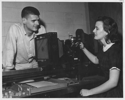 Alanna Mangelsen and her laboratory partner, Russell Swanson, are pictured with a metallograph, an instrument for examining and photographing the fine structure of alloy specimens