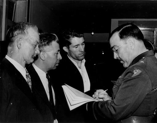 An officer reading some document to three men