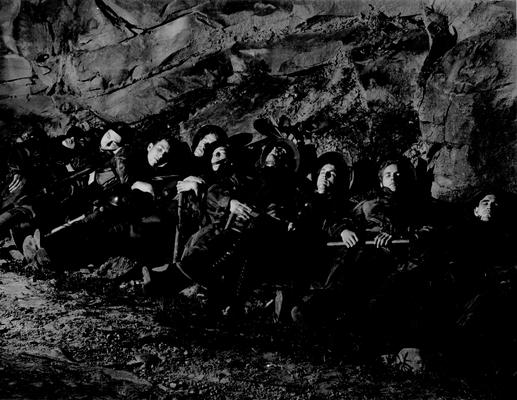 Nine miners sitting in a coal mine