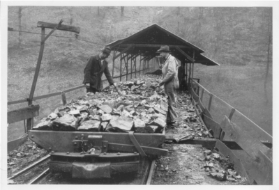 Coal cars coming from the opening to a mine: 