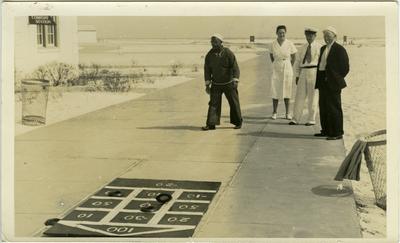 William Green and two unidentified males in Naval uniform and one unidentified female in uniform playing shuffleboard