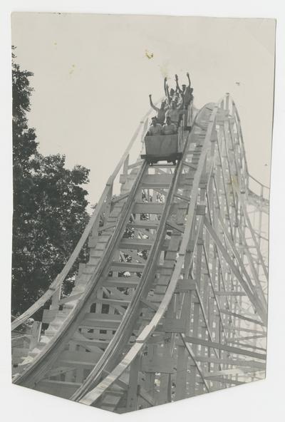 Riders going downhill on a roller coaster with their arms in the air, amusement attraction, Joyland Park - stamped on back of photograph MACK HUGHES PHOTOGRAPH 503 E. HIGH LEXINGTON, KY